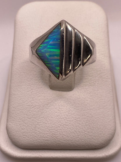 Anillo de plata .950 con ópalo de fuego azul cielo mostrando vetas de color en la mano