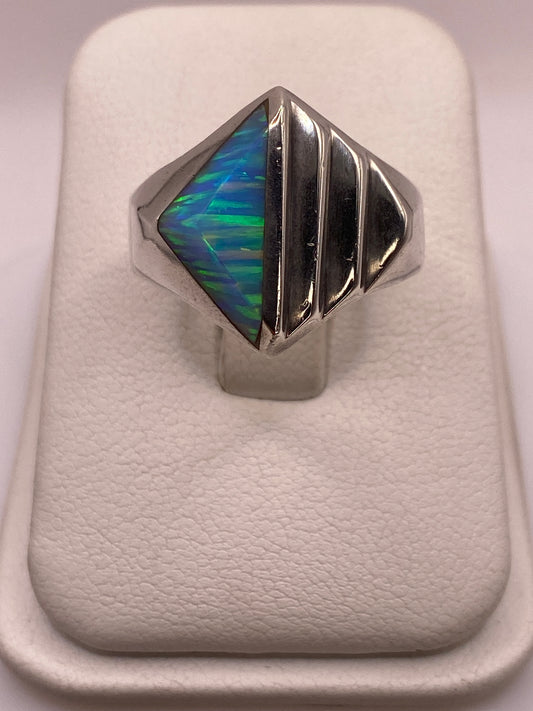 Anillo de plata .950 con ópalo de fuego azul cielo mostrando vetas de color en la mano