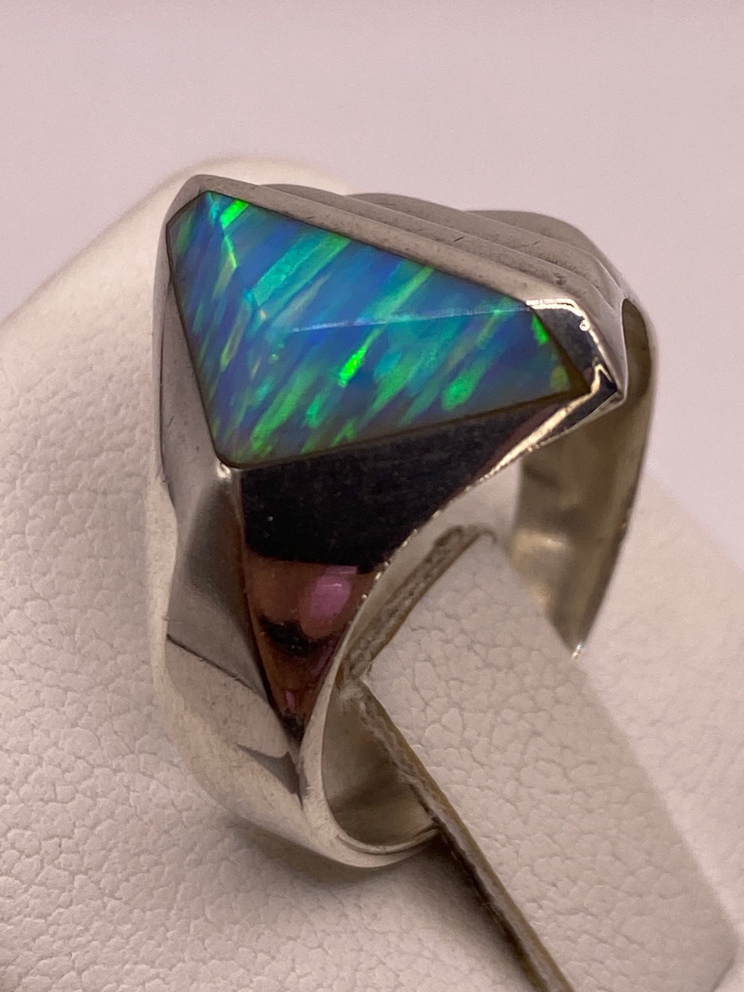 Detalle de la piedra ópalo de fuego con juego azul y verde bajo la luz