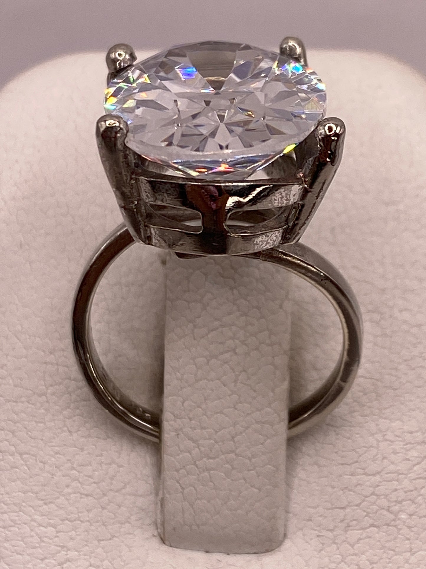 Anillo de plata solitario con circonia cristalina grande en la mano de una mujer
