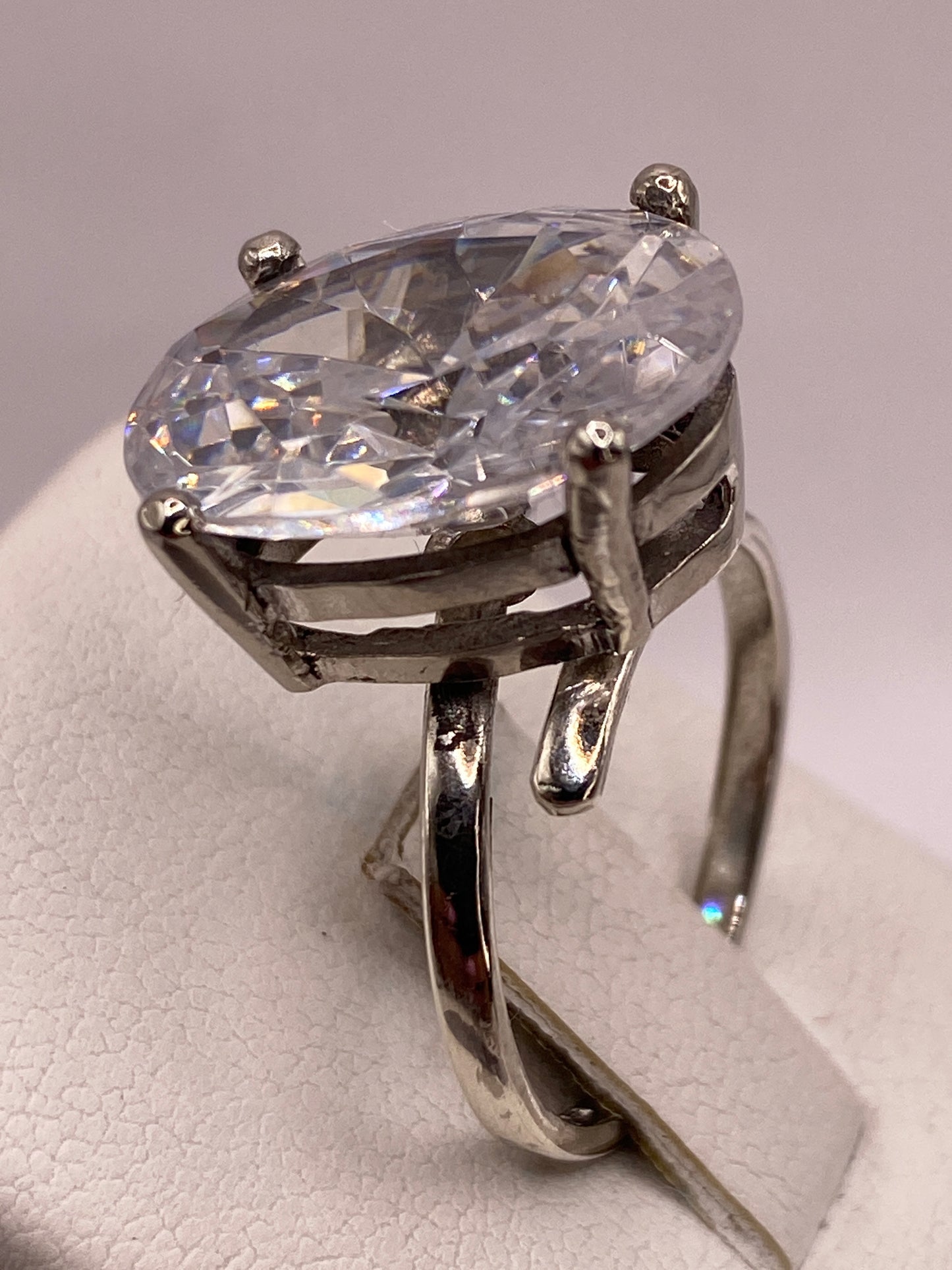 Anillo solitario sobre fondo neutro con detalle del engaste a mano en plata de Taxco