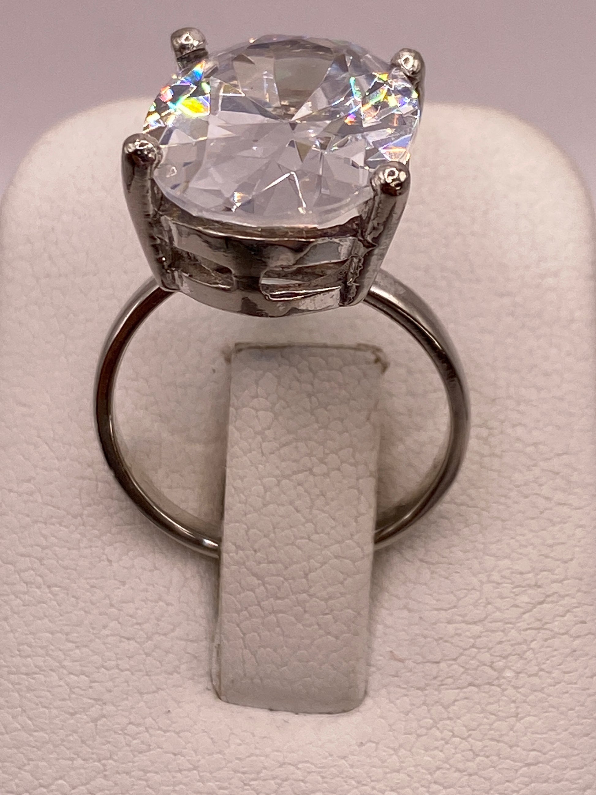 Anillo solitario de plata con circonia cristalina engastado en cuatro puntas sobre fondo blanco