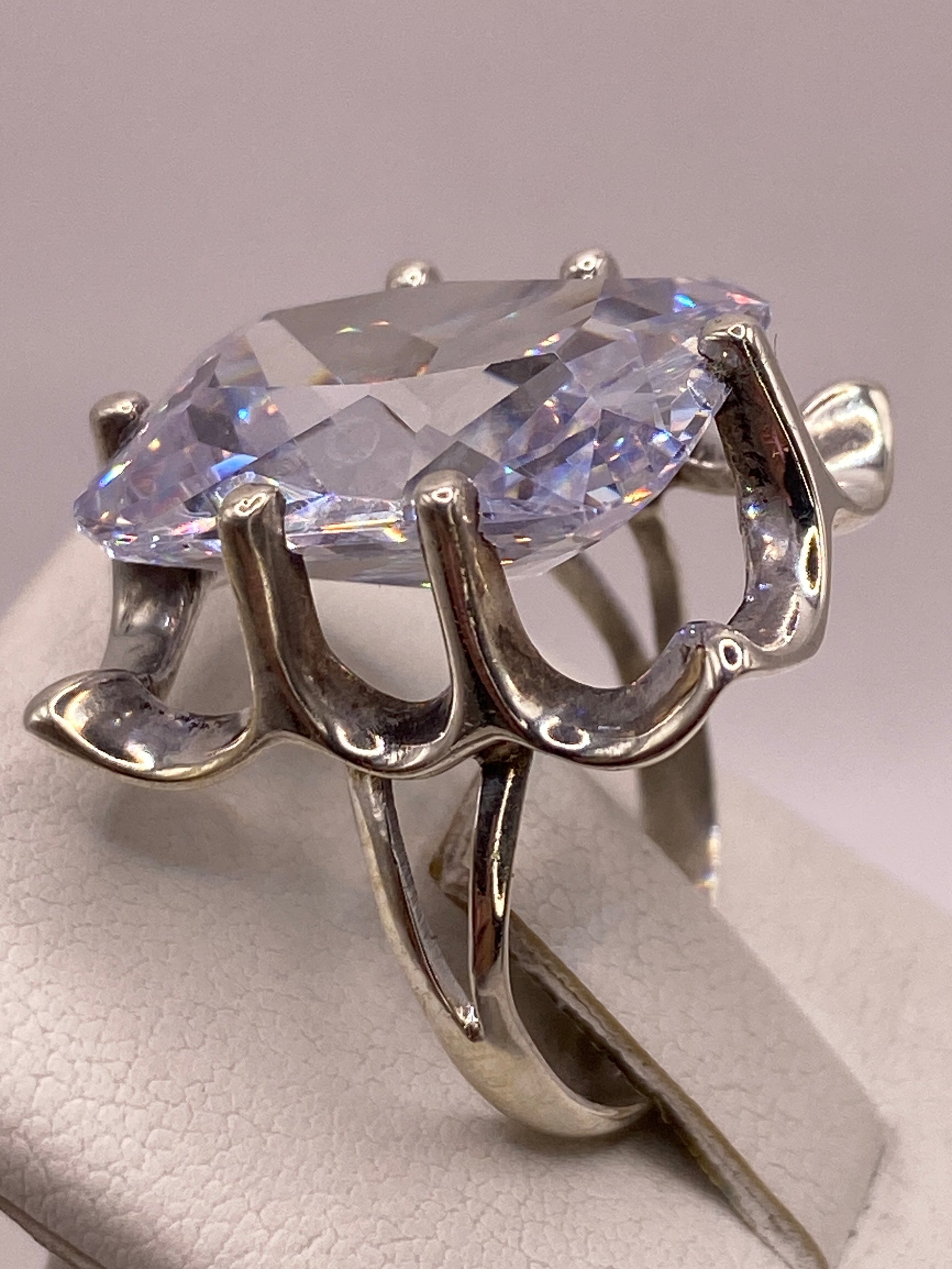 Anillo en la mano con esmalte de uñas rosa, mostrando el brillo diamantino de la circonia