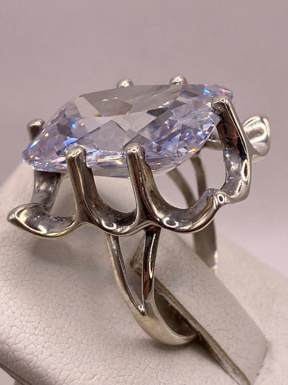 Anillo en la mano con esmalte de uñas rosa, mostrando el brillo diamantino de la circonia