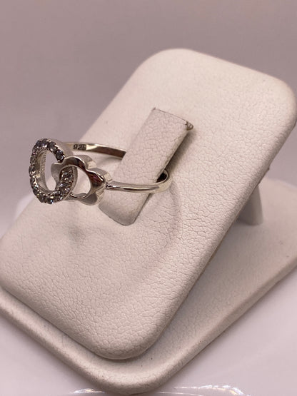 Detalle lateral del anillo mostrando el engaste a mano de la circonia blanca
