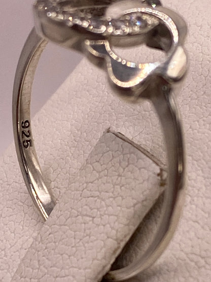 Anillo solitario en mano de mujer con esmalte rosa, iluminando el brillo de la circonia