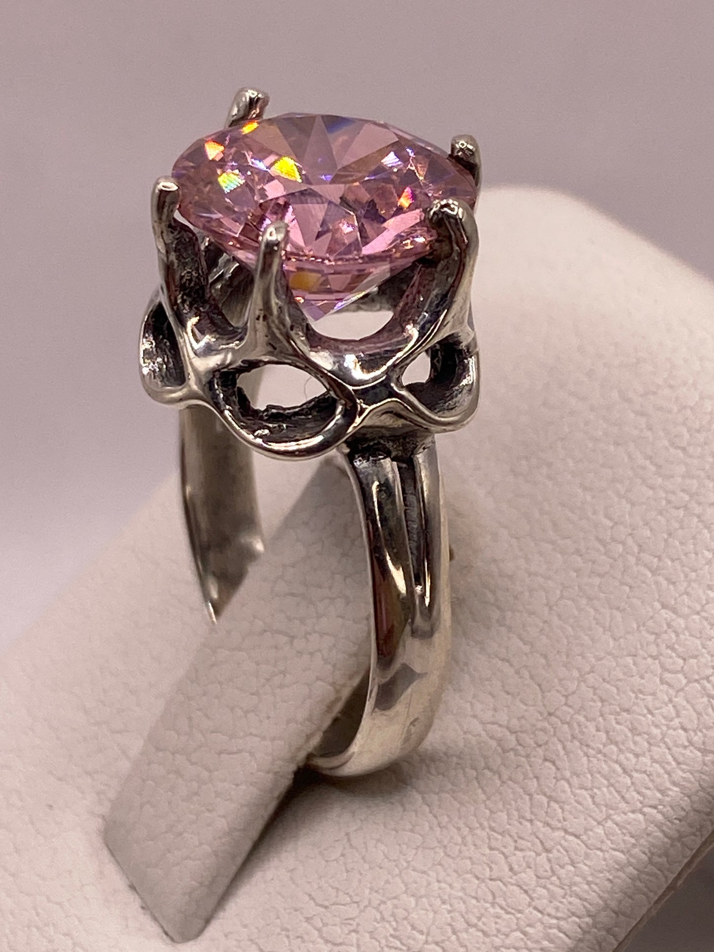 Detalle de la circonia rosa con brillo tipo diamante capturando luz dorada y azul