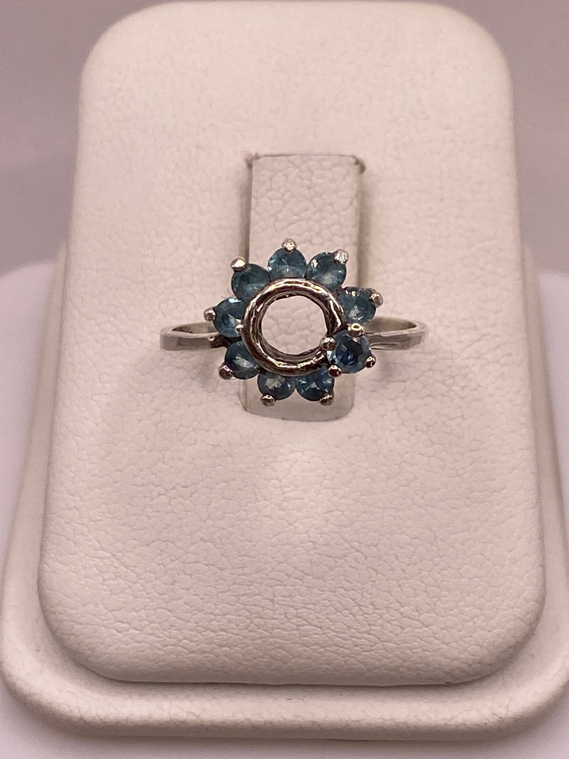 Anillo de plata solitario con circonia azul cielo en mano de mujer con esmalte rosa