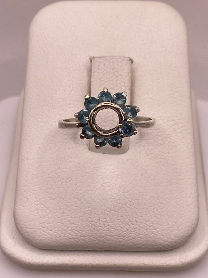 Anillo de plata solitario con circonia azul cielo en mano de mujer con esmalte rosa
