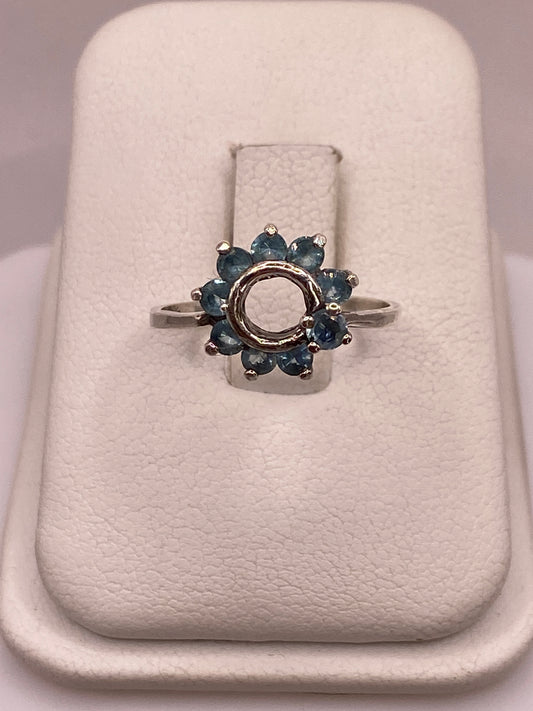Anillo de plata solitario con circonia azul cielo en mano de mujer con esmalte rosa