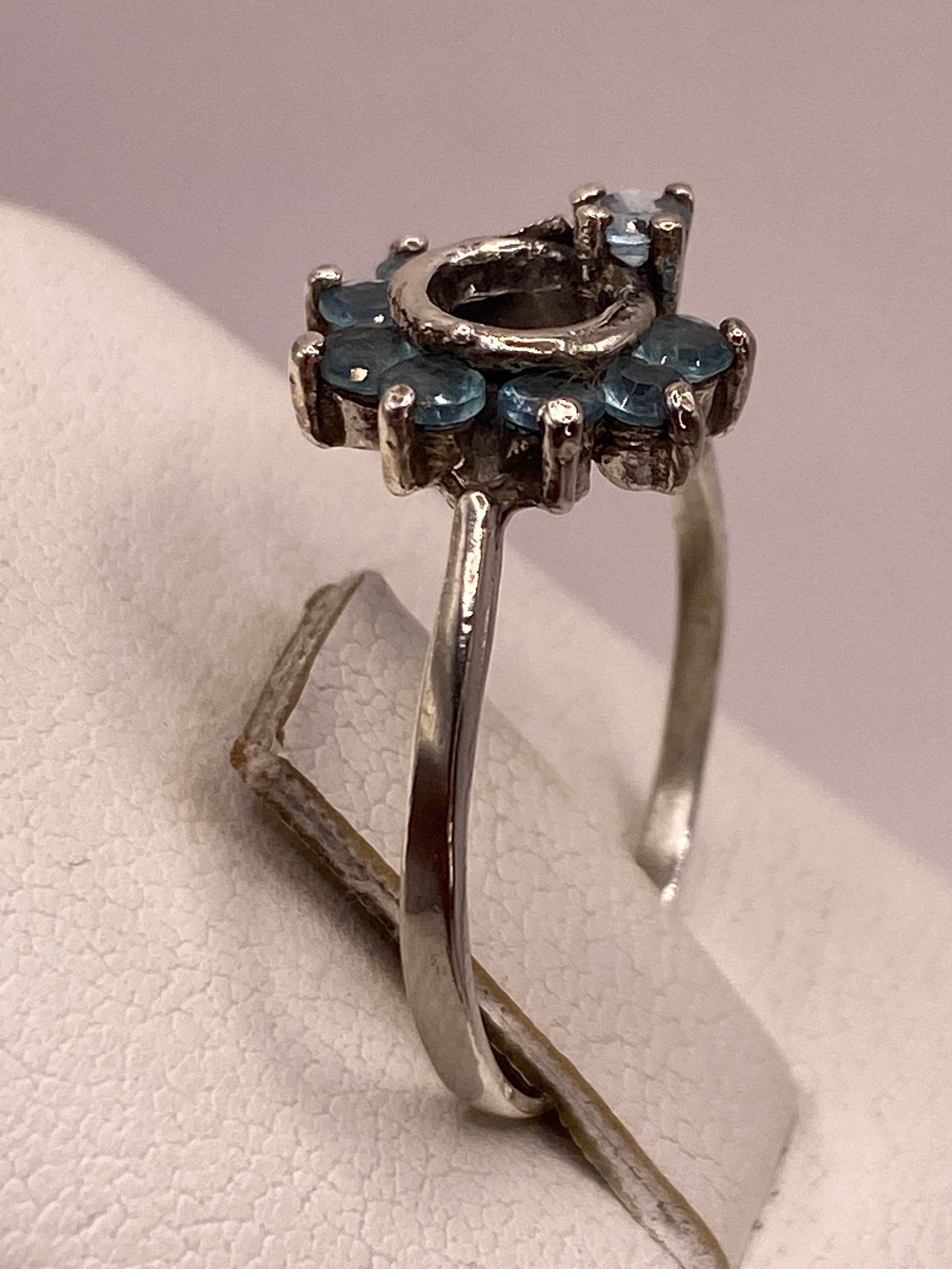 Detalle lateral del anillo mostrando la banda pulida en espejo y el engaste a mano