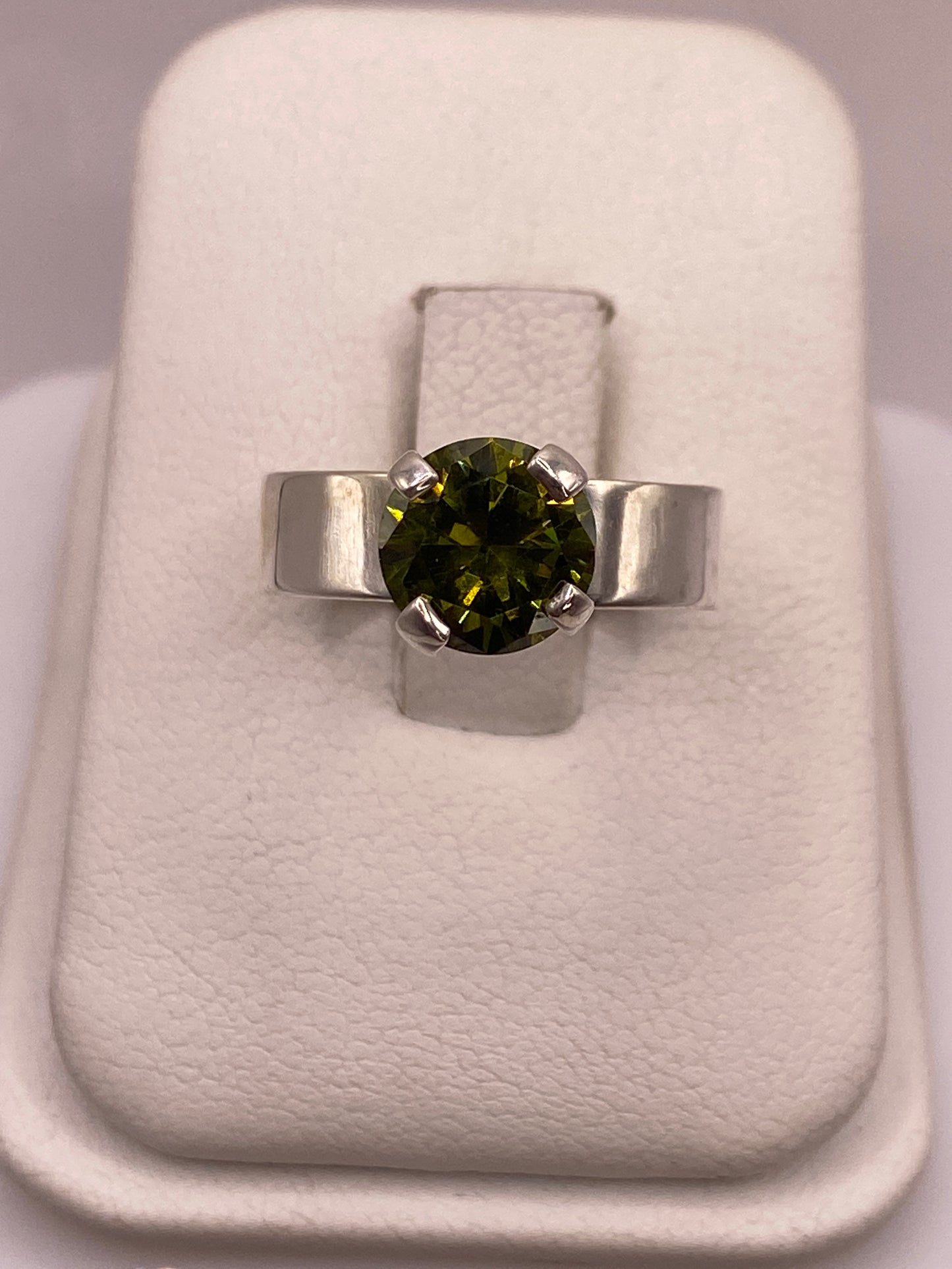 Anillo solitario de plata con circonia verde oliváceo en estuche blanco de presentación