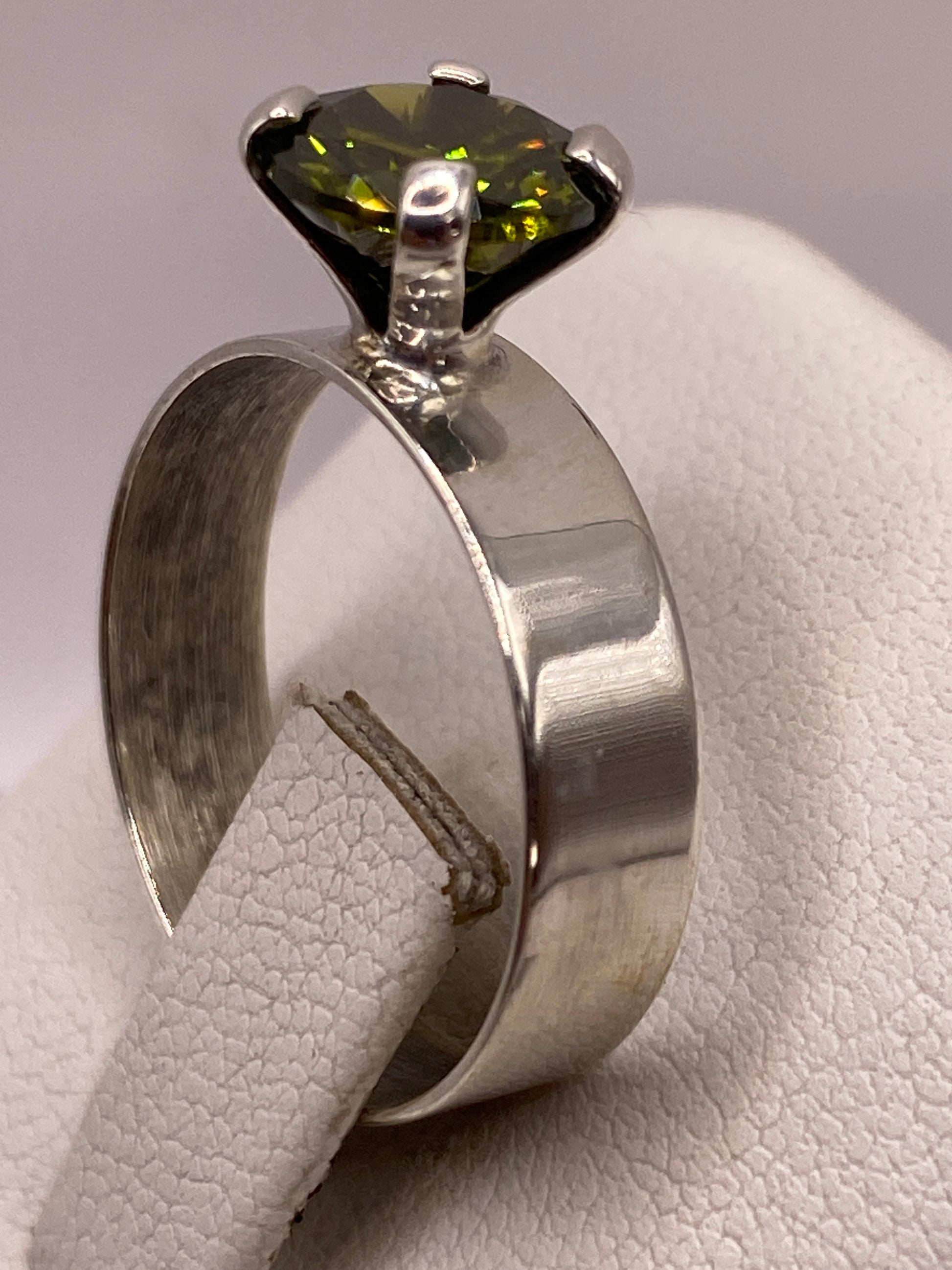 Detalle frontal de la circonia verde facetada sobre plata .925
