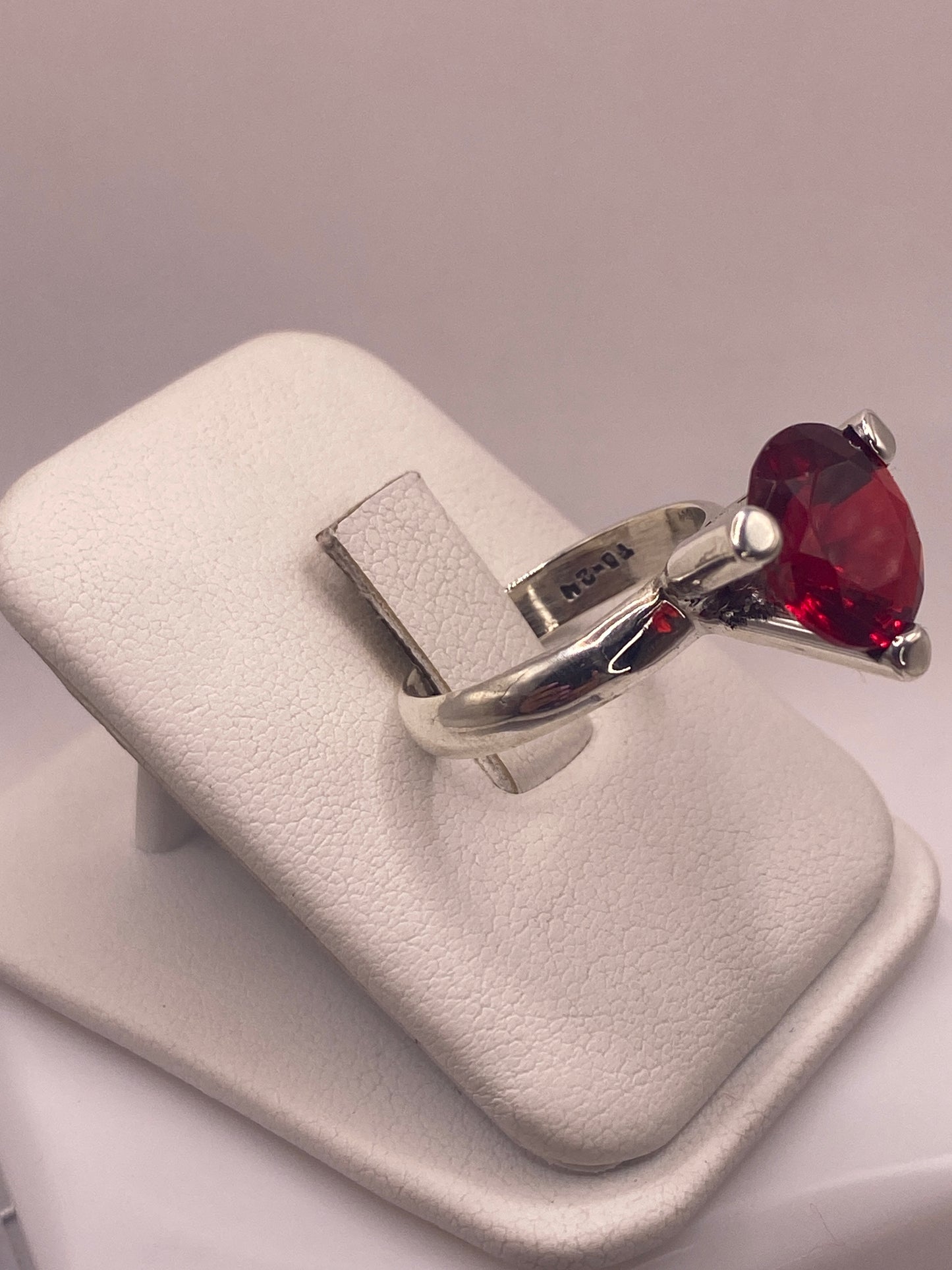 Vista lateral del anillo coctel rojo mostrando el engaste de cuatro puntas en plata pura