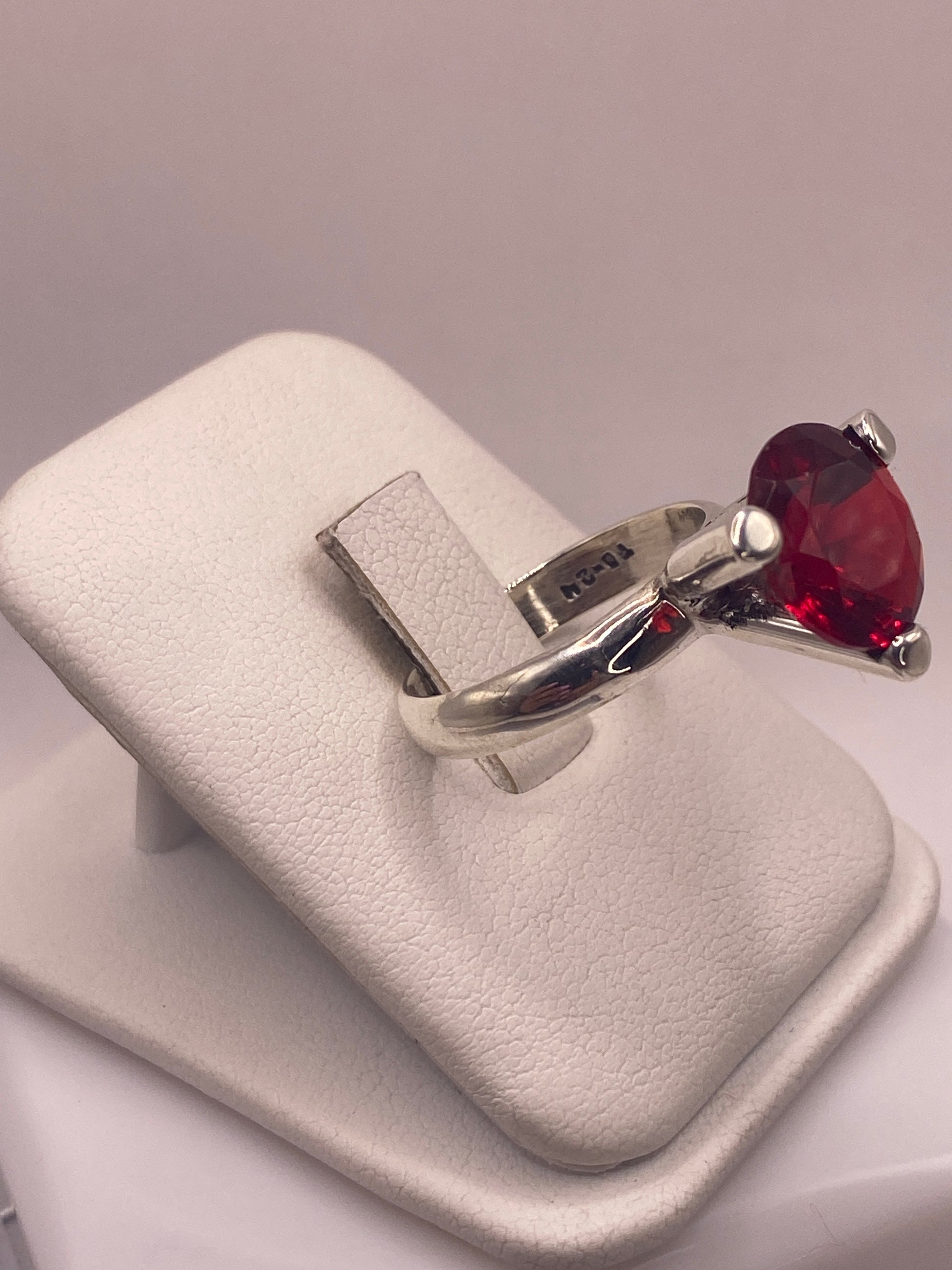 Vista lateral del anillo coctel rojo mostrando el engaste de cuatro puntas en plata pura