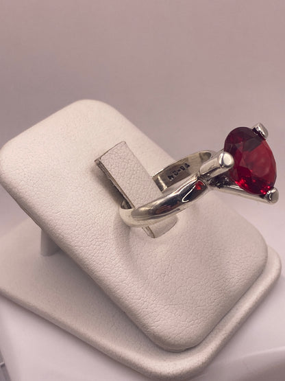 Vista lateral del anillo coctel rojo mostrando el engaste de cuatro puntas en plata pura
