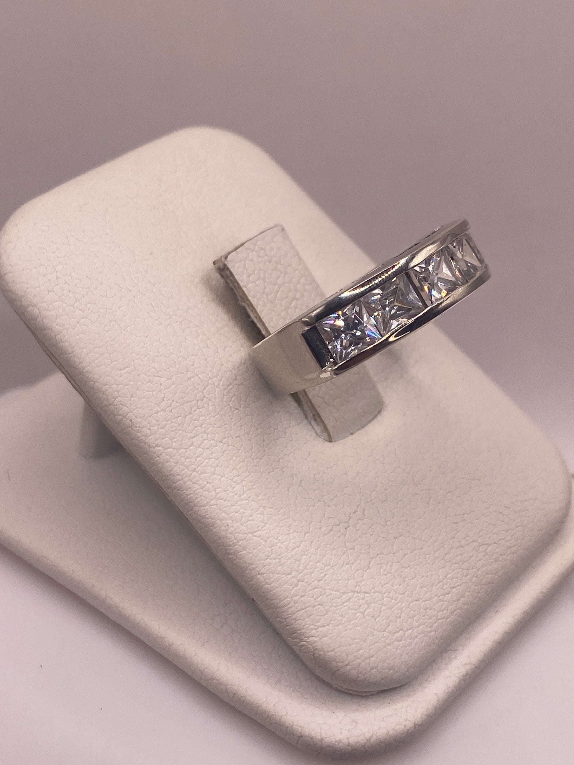 Vista frontal del anillo minimalista con piedra blanca pulida en la mano