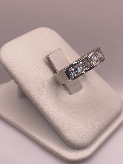 Vista frontal del anillo minimalista con piedra blanca pulida en la mano