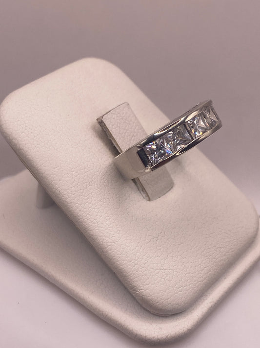 Vista frontal del anillo minimalista con piedra blanca pulida en la mano