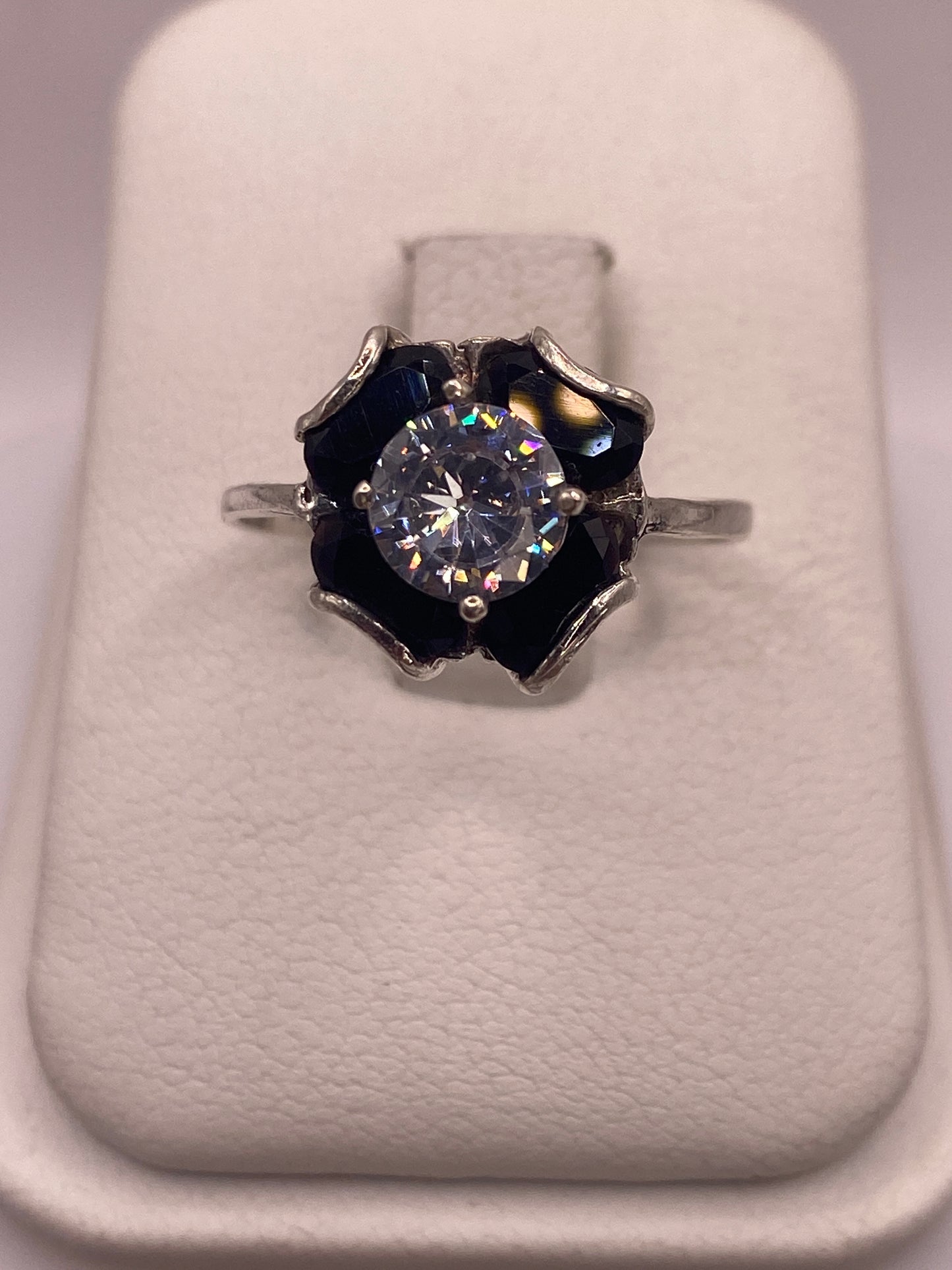 Anillo solitario de plata .925 con circonia multicolor brillante, vista frontal en estuche blanco