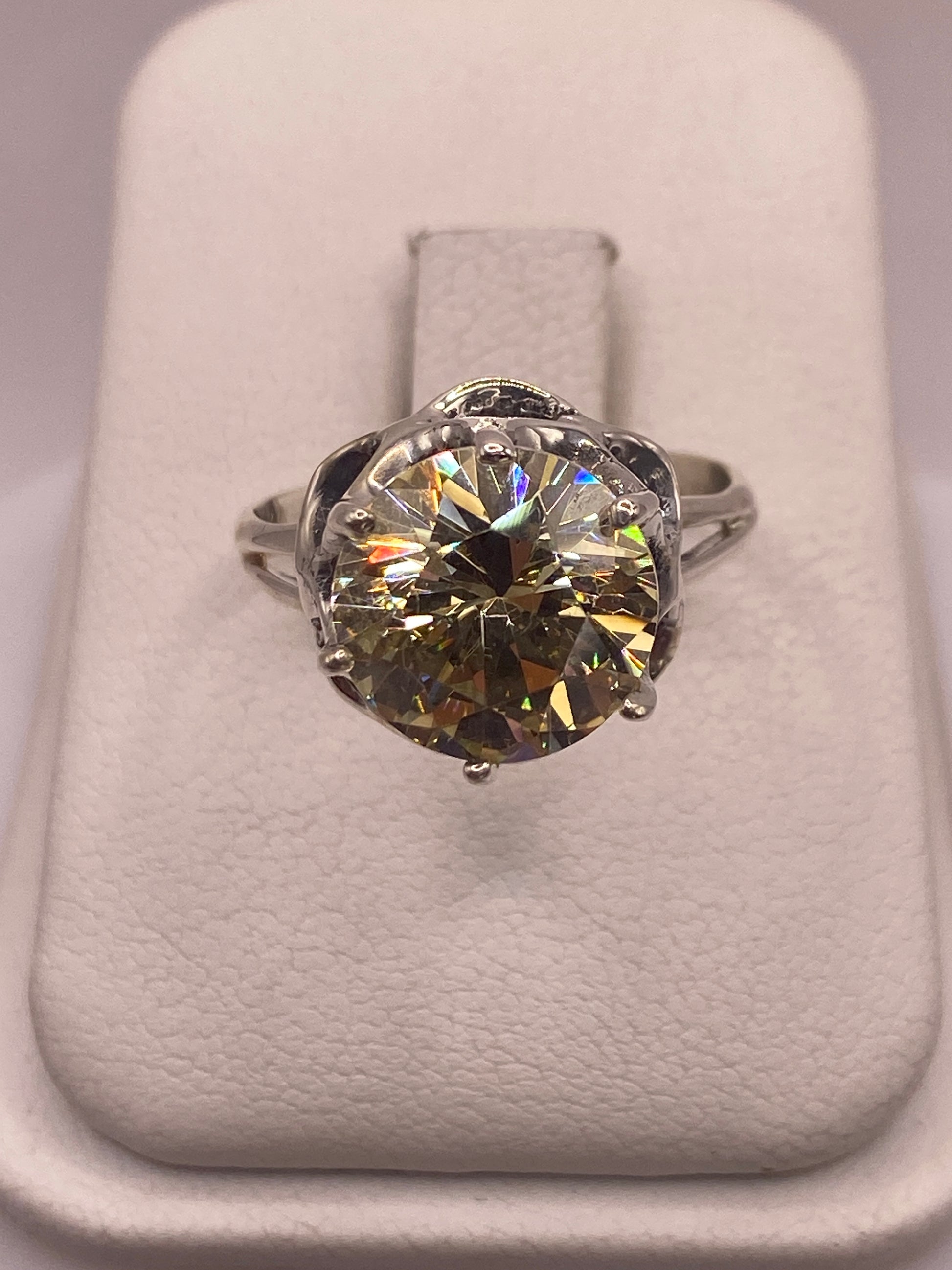 Anillo de plata solitario con circonia amarilla engastada, vista frontal en estuche blanco