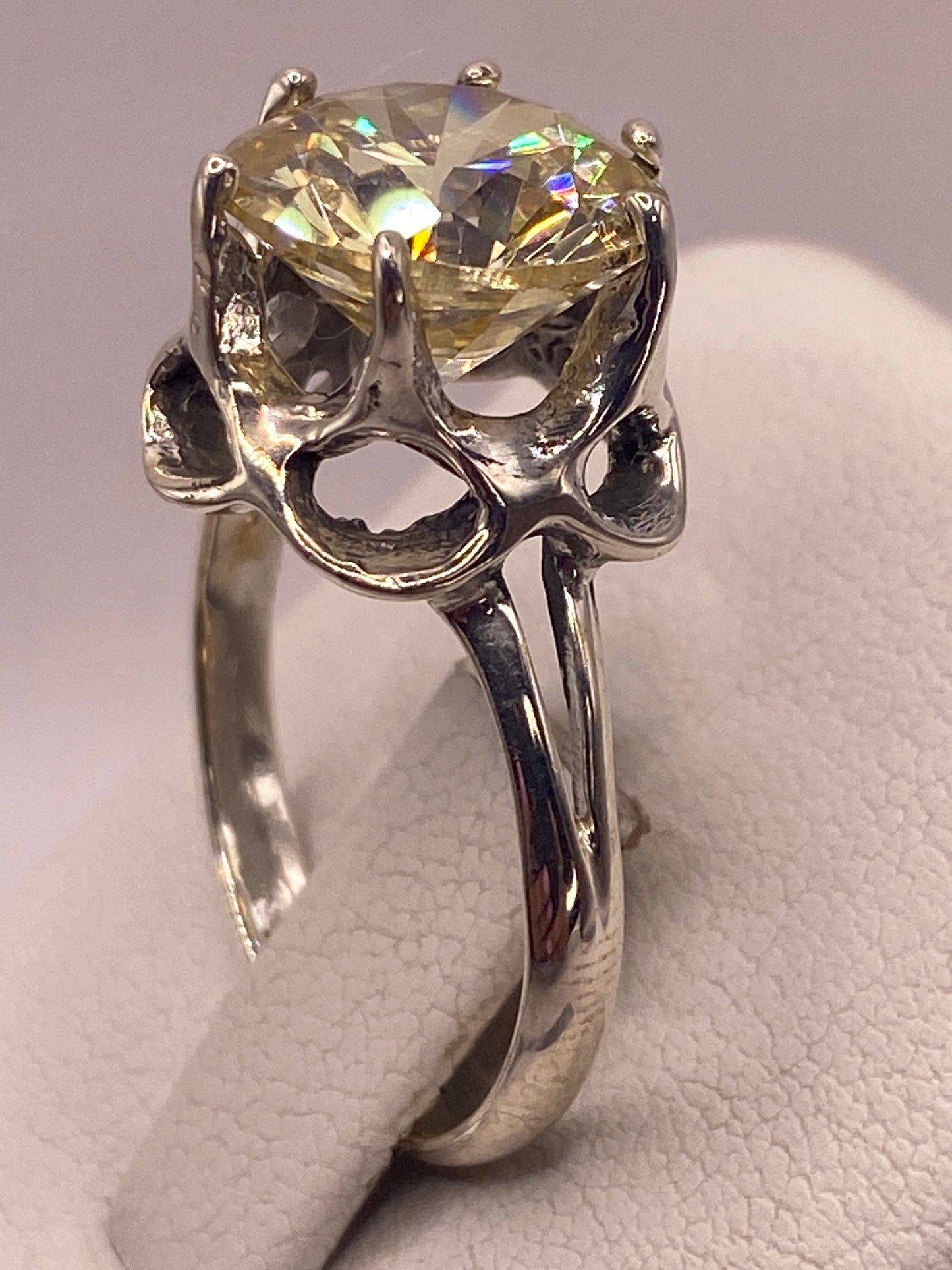 Anillo solitario de plata .925 con circonia amarilla en la mano, mostrando brillo tipo diamante