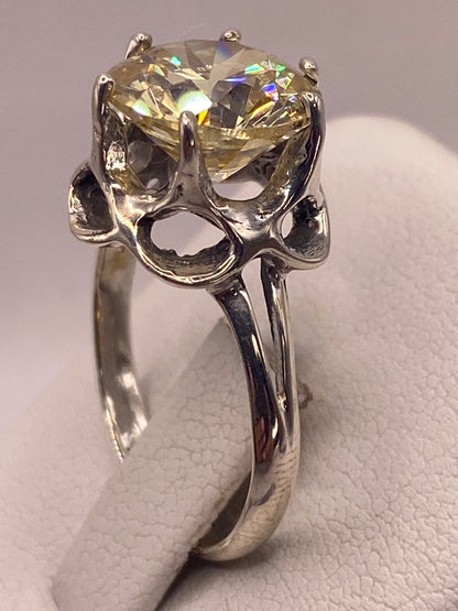 Anillo solitario de plata .925 con circonia amarilla en la mano, mostrando brillo tipo diamante