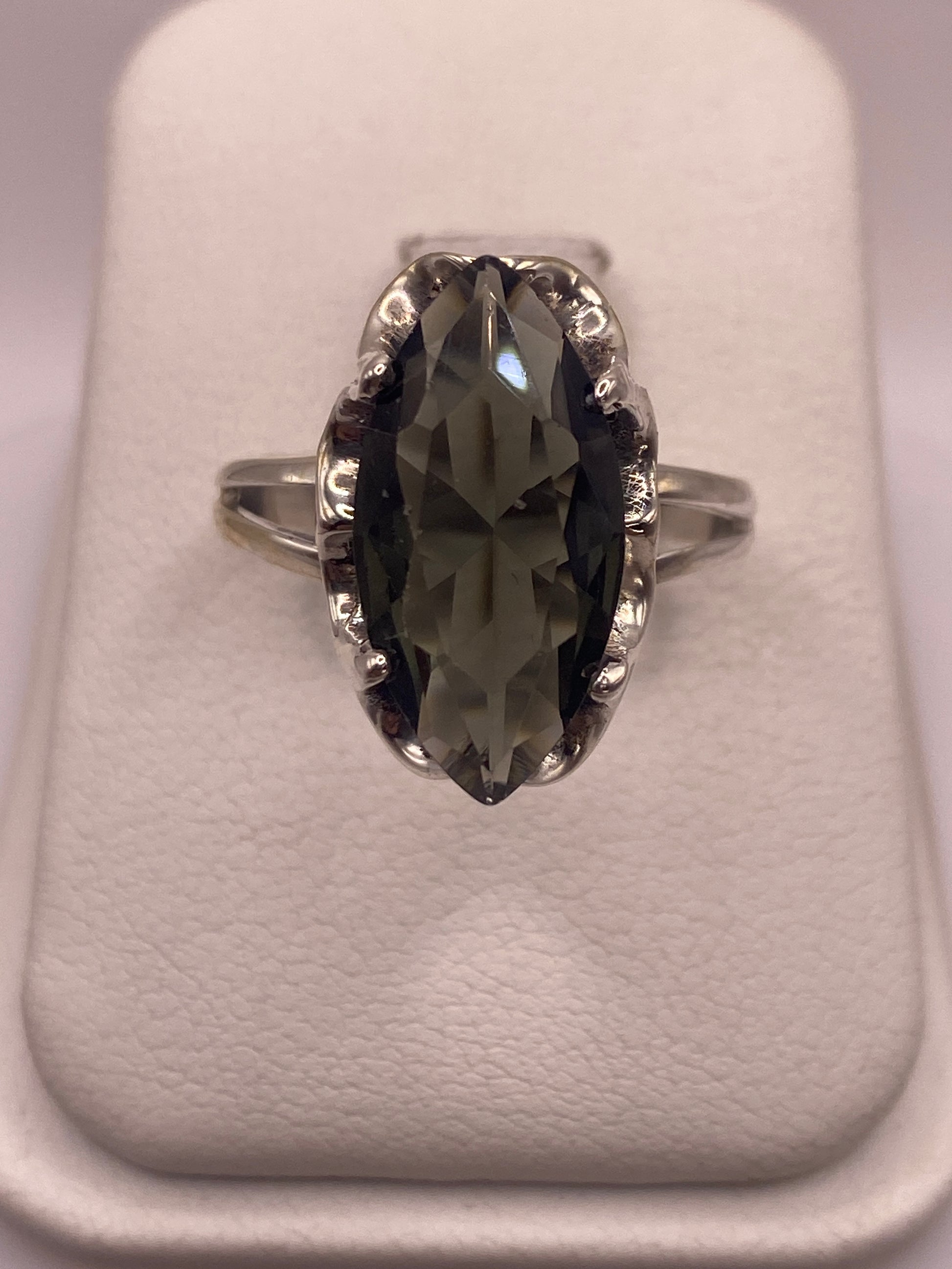 Anillo de plata solitario con circonia gris ahumado facetada, vista frontal sobre fondo blanco