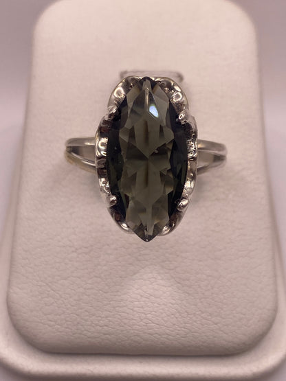 Anillo de plata solitario con circonia gris ahumado facetada, vista frontal sobre fondo blanco