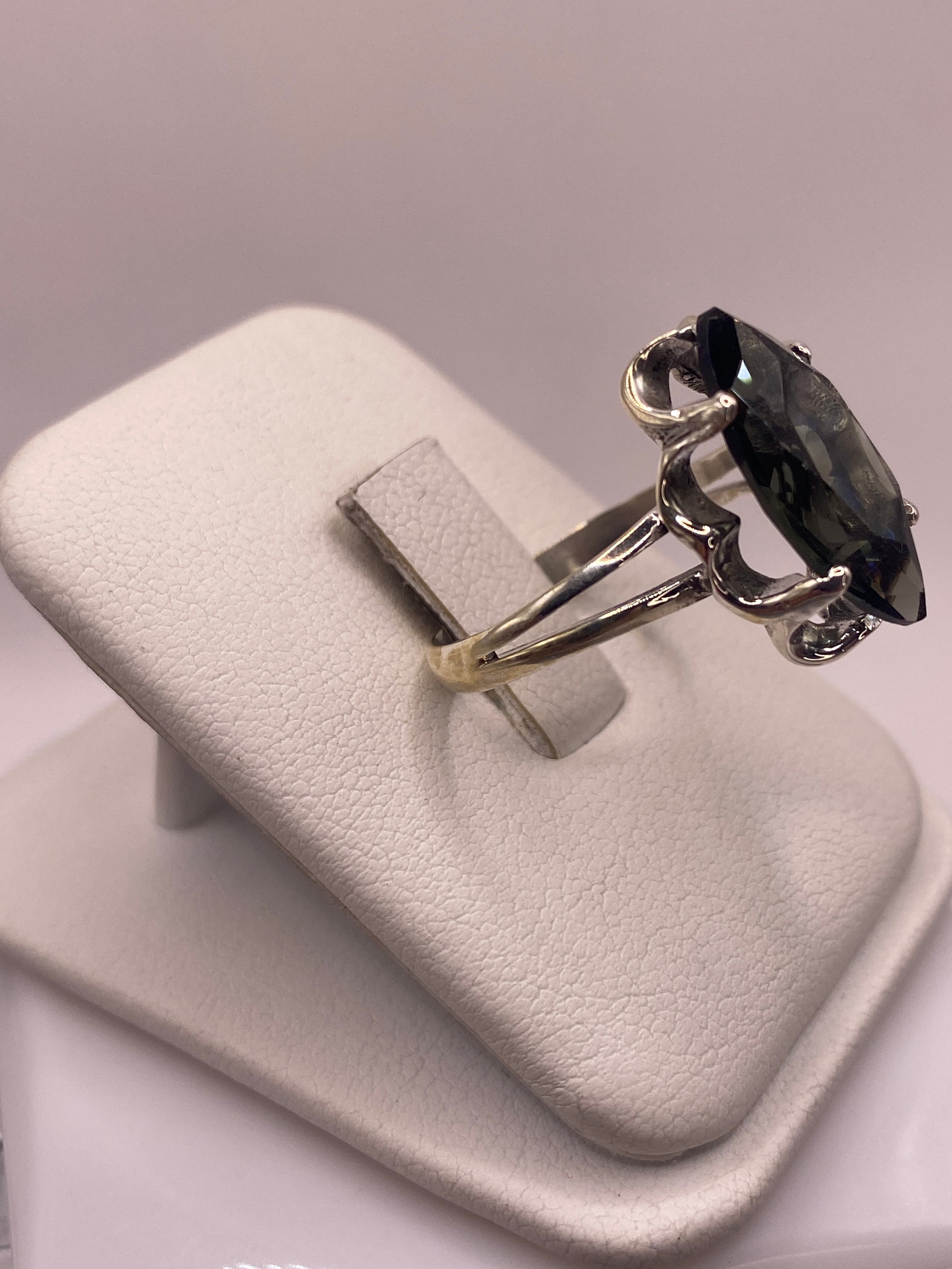 Anillo de plata .925 con circonia gris ahumado en la mano, mostrando el brillo y facetas