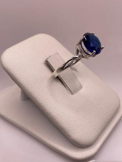 Vista frontal del anillo con circonia azul tono zafiro en la mano