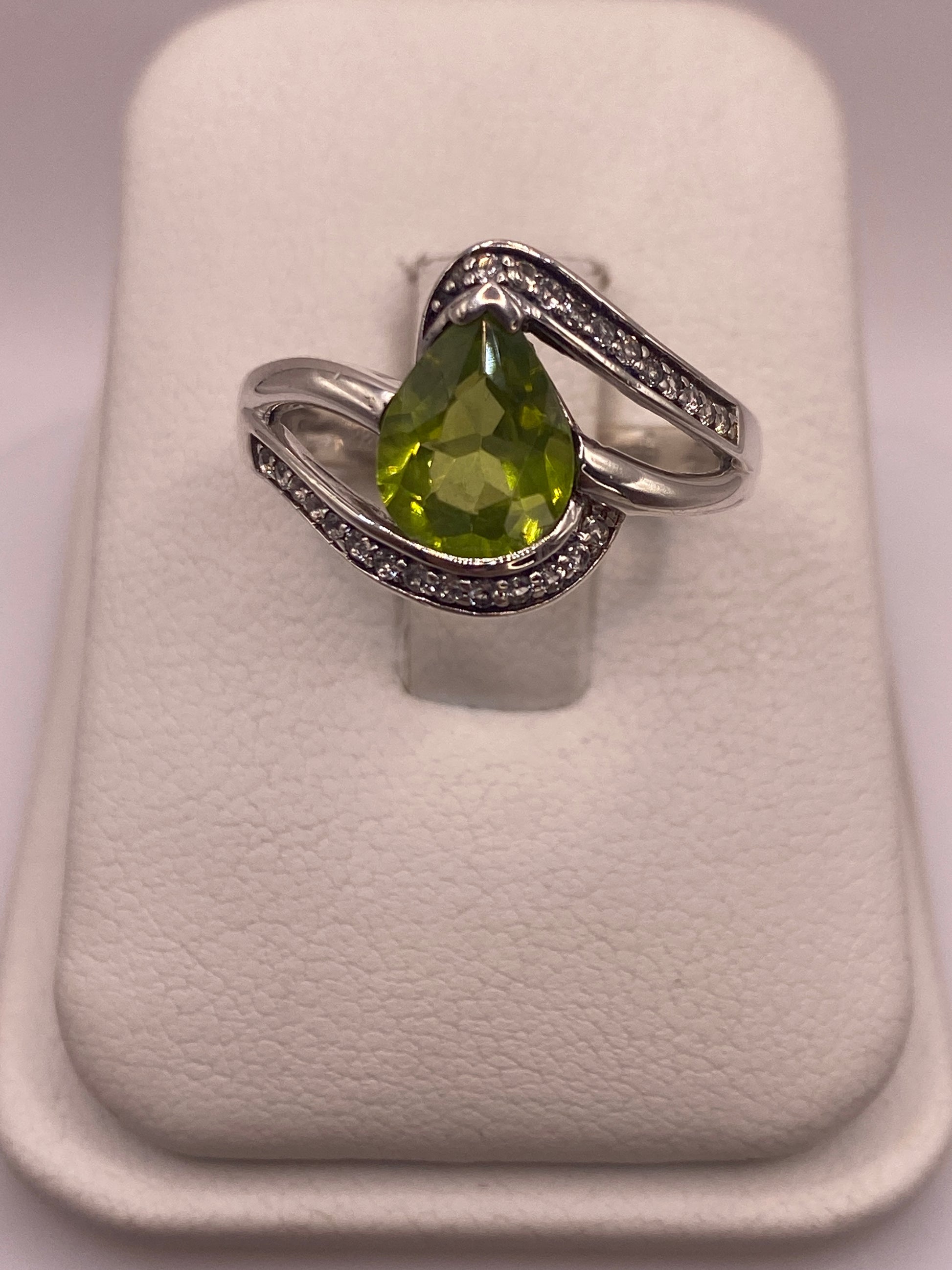 Anillo de plata solitario con circonia verde limón facetada sobre fondo blanco