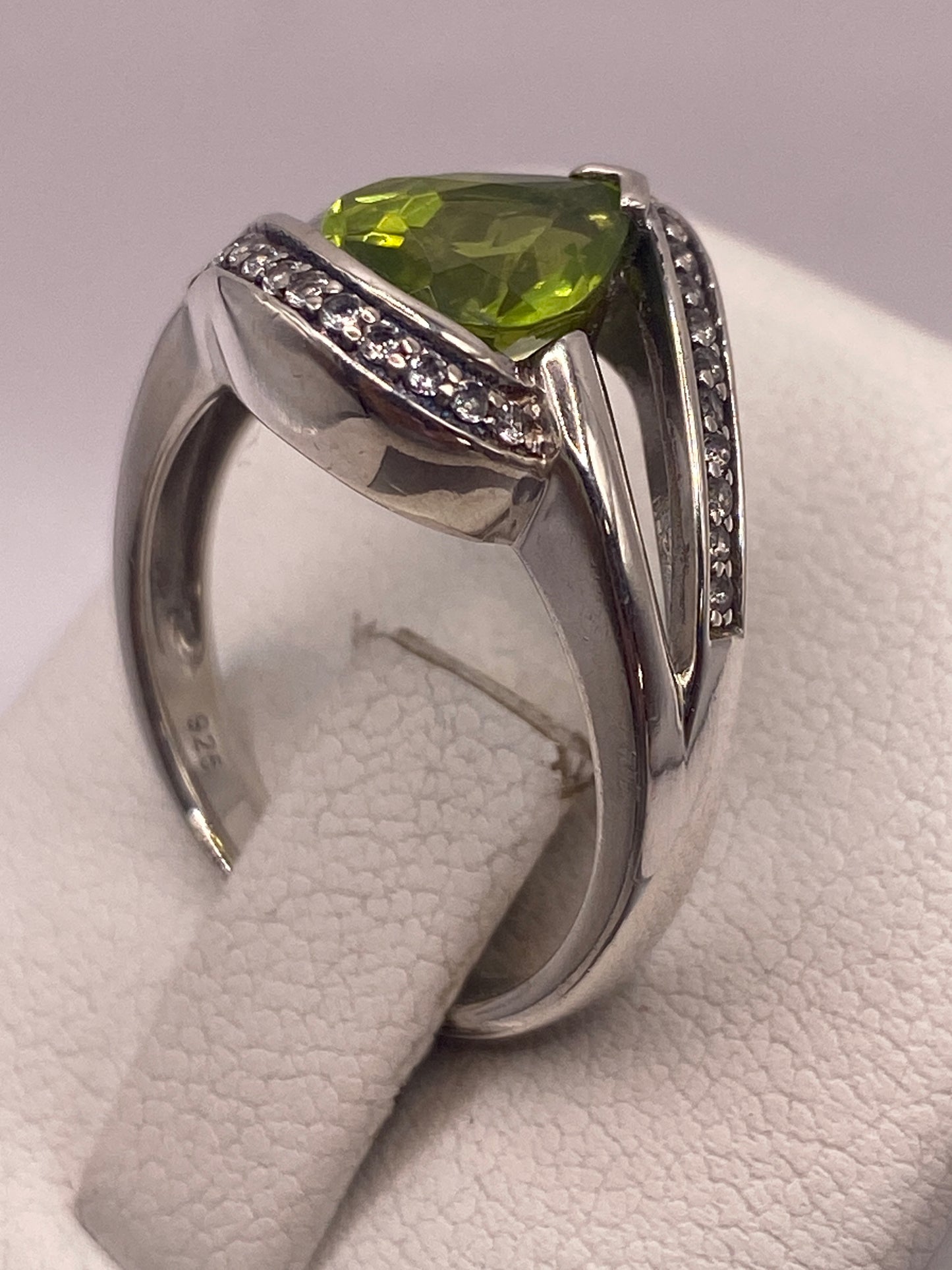 Anillo colocado en dedo mostrando el brillo verde limón de la piedra