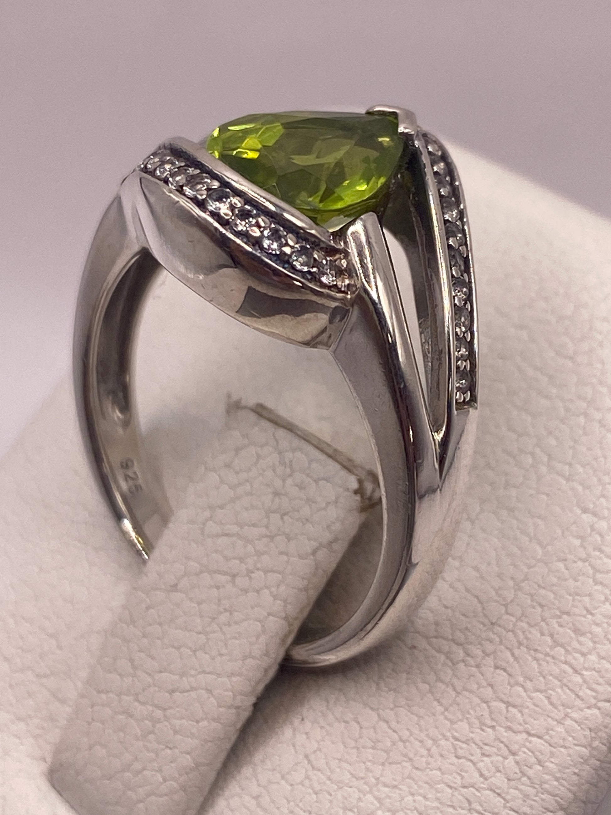 Anillo colocado en dedo mostrando el brillo verde limón de la piedra