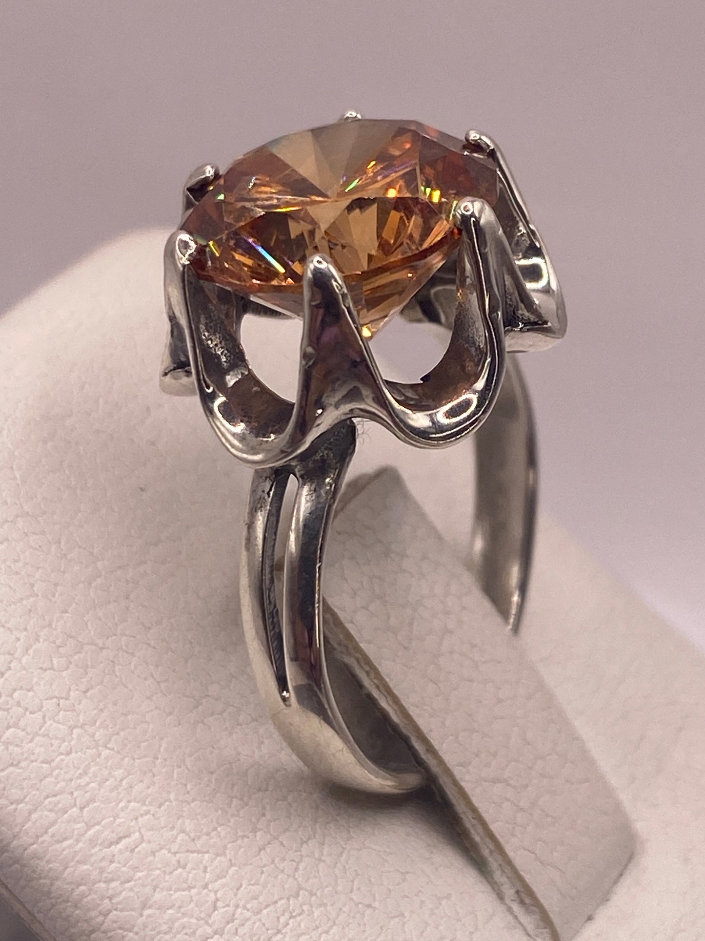 Anillo solitario de perfil mostrando la corona y el engaste artesanal a mano de la piedra champagne