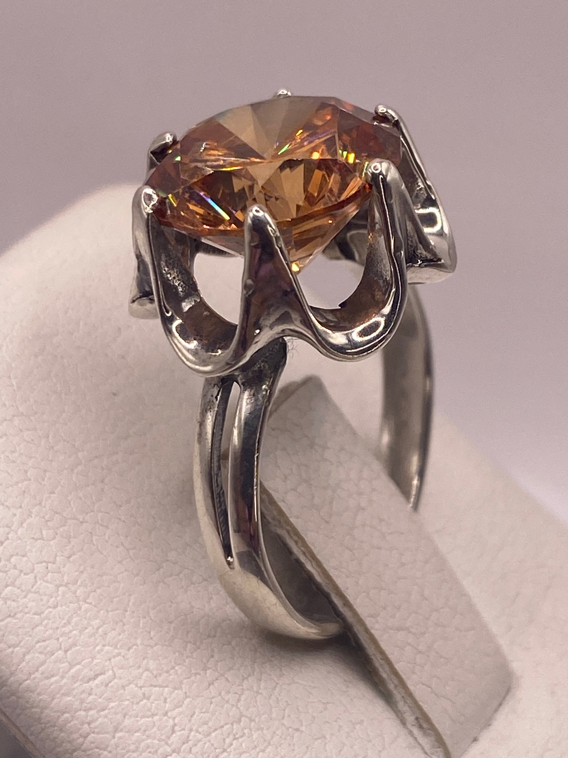 Anillo solitario de perfil mostrando la corona y el engaste artesanal a mano de la piedra champagne