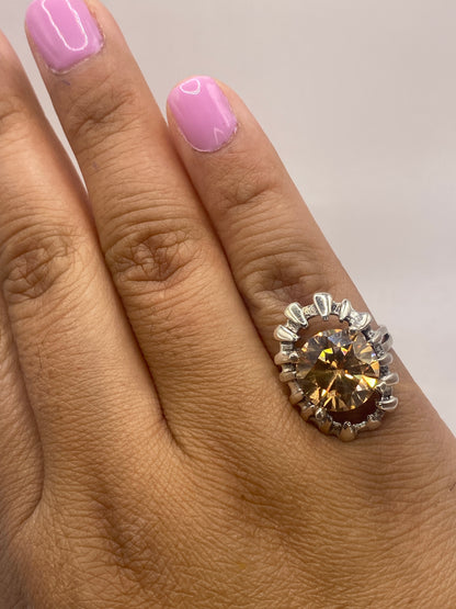 Anillo de circonia café en la mano mostrando el brillo y fuego de la piedra