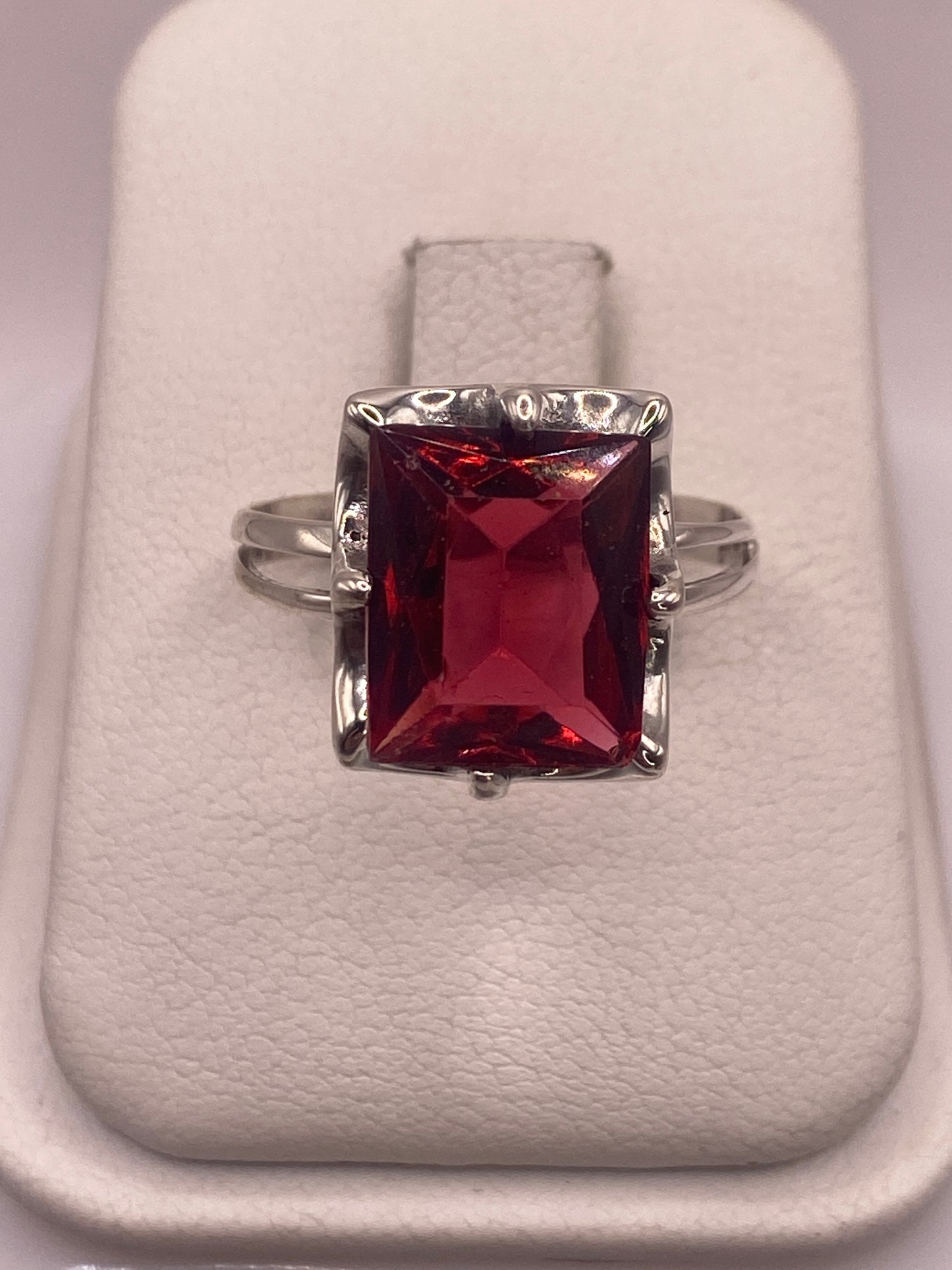 Anillo de plata .925 con circonia roja rectangular en estuche blanco, vista frontal