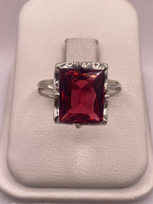 Anillo de plata .925 con circonia roja rectangular en estuche blanco, vista frontal