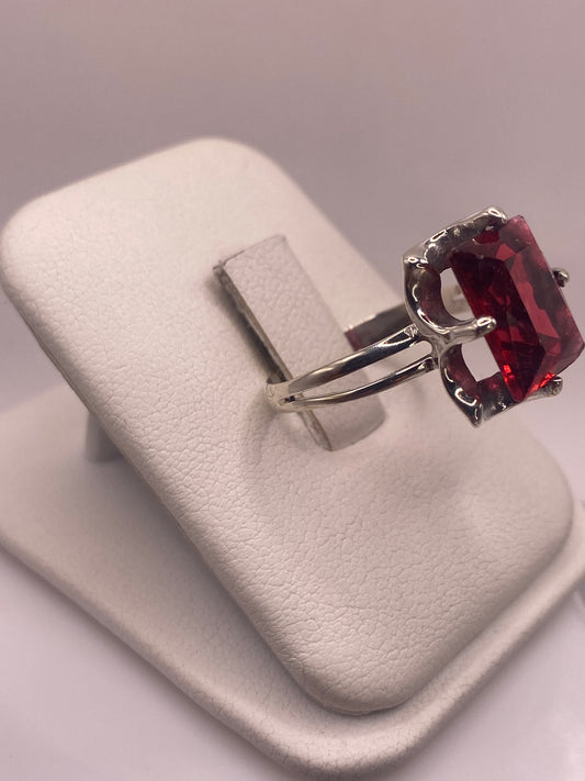 Anillo solitario circonia roja en la mano, mostrando el fuego rojo intenso