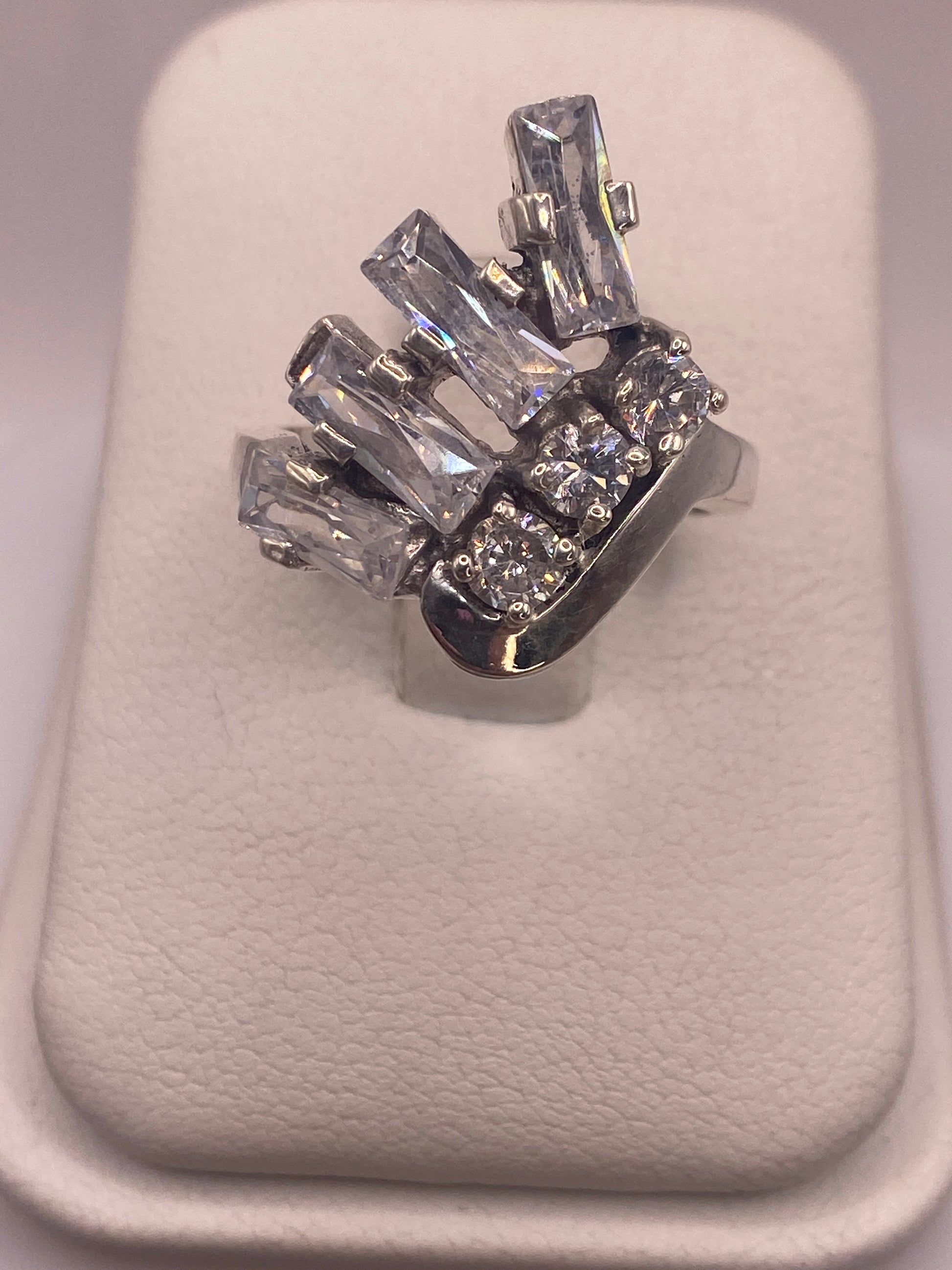 Anillo solitario de plata con circonia blanca brillante engastada a mano, vista frontal sobre blanco