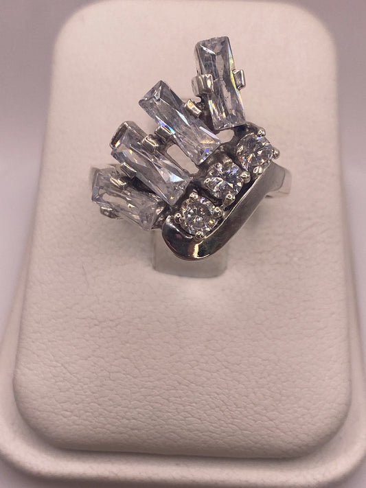 Anillo solitario de plata con circonia blanca brillante engastada a mano, vista frontal sobre blanco