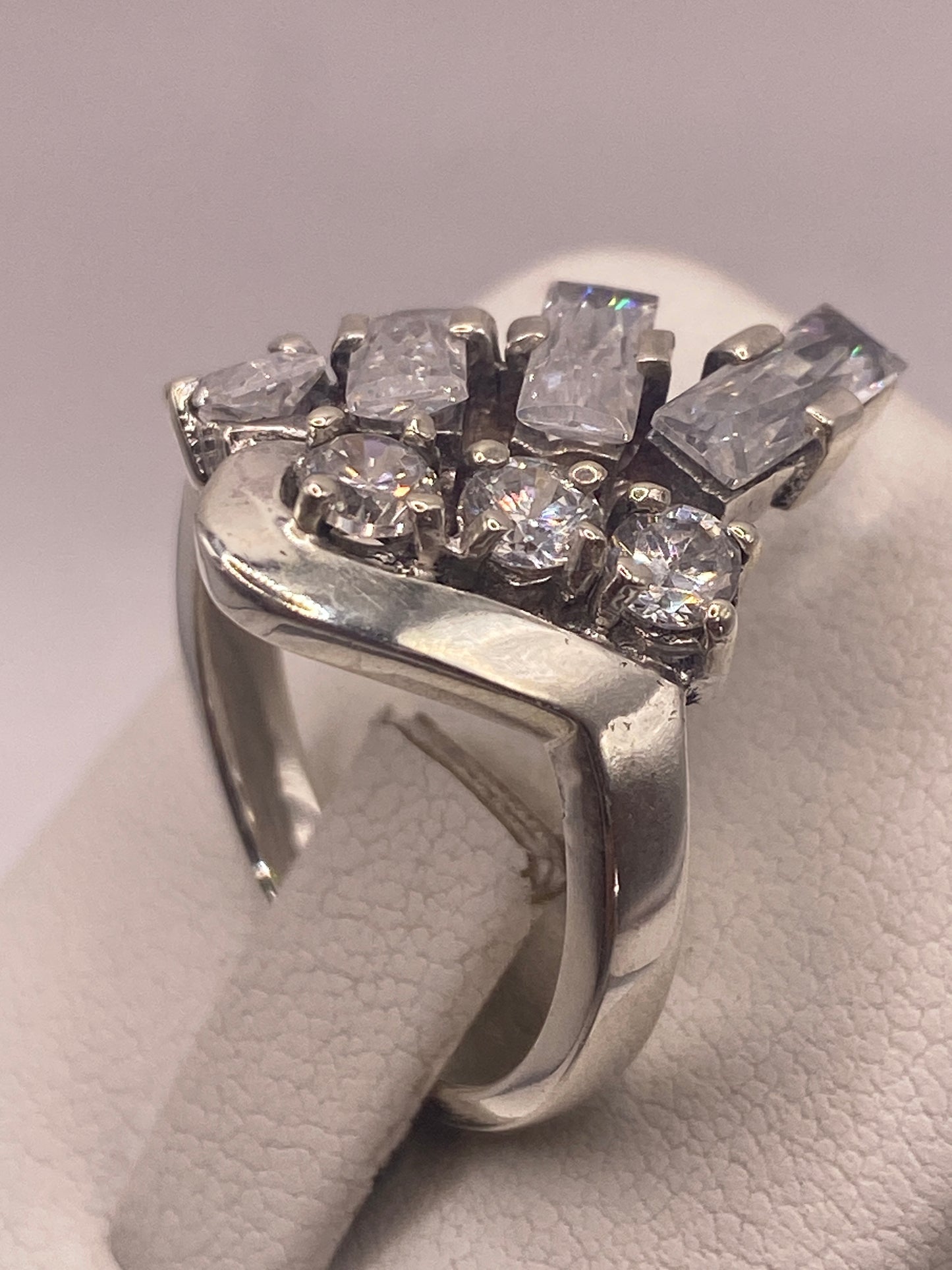 Anillo solitario en dedo con manicura rosa, brillo cristalino de la circonia visible