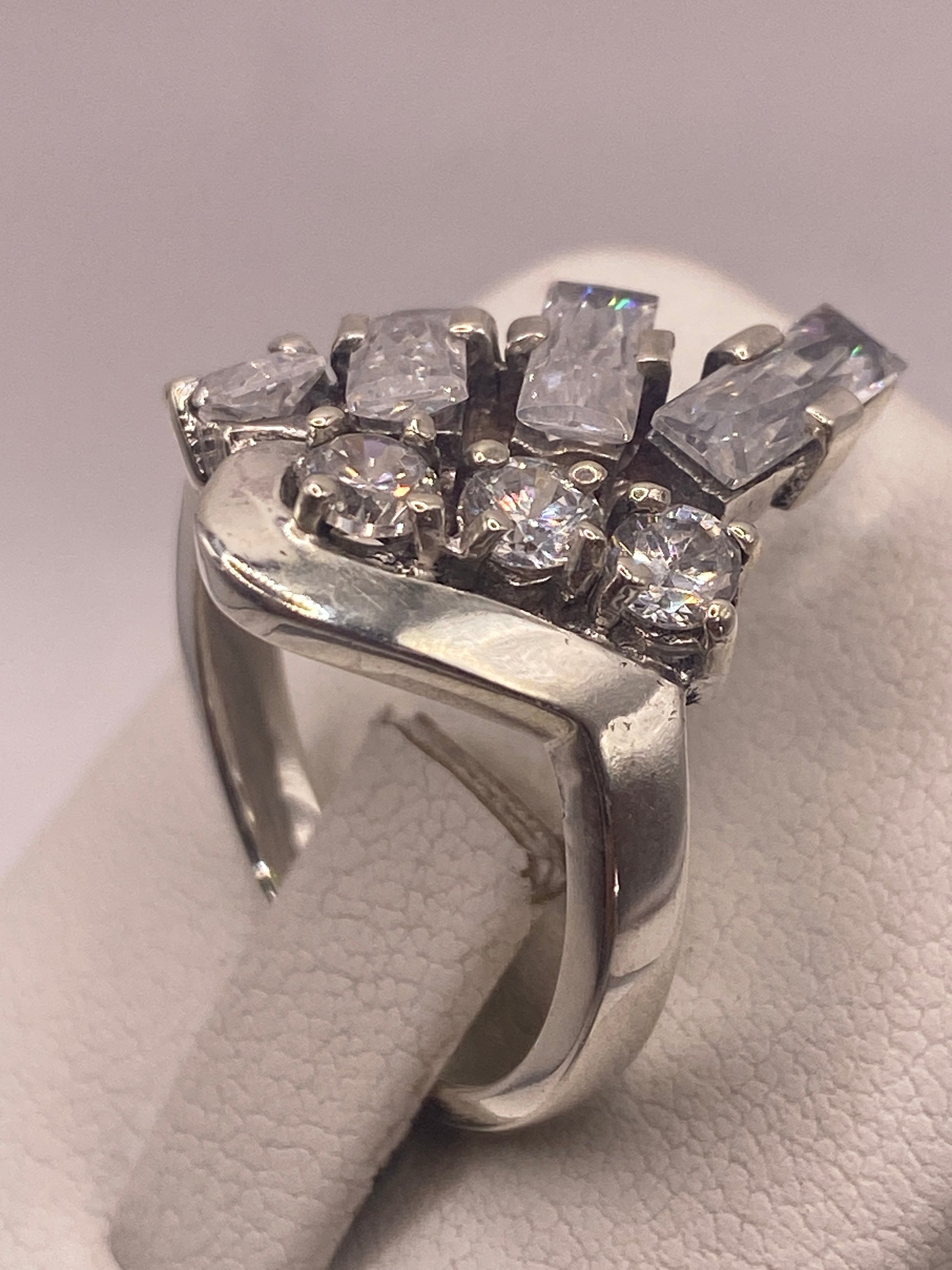Anillo solitario en dedo con manicura rosa, brillo cristalino de la circonia visible