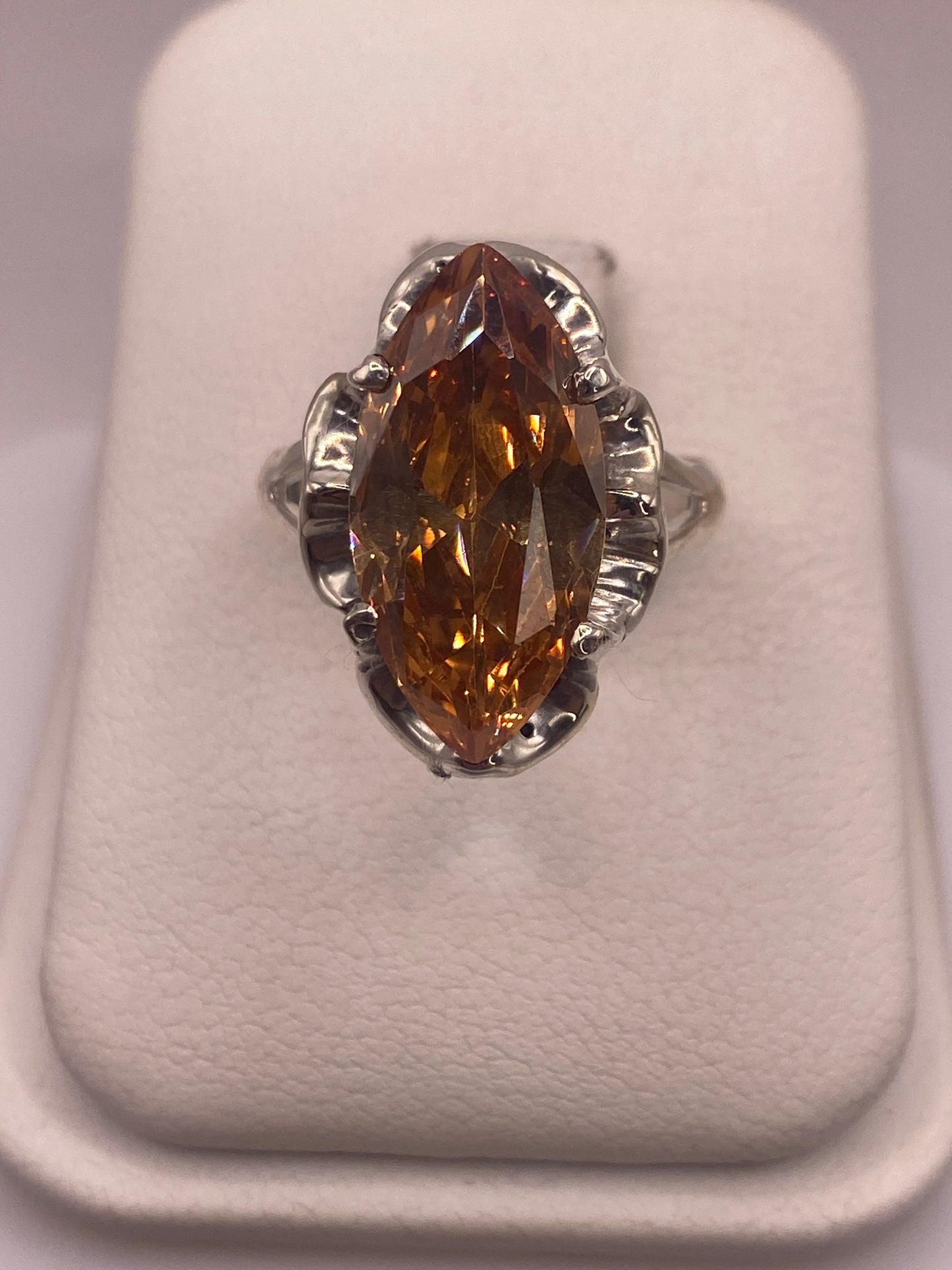 Anillo de plata solitario con circonia café facetada en vitrina blanca