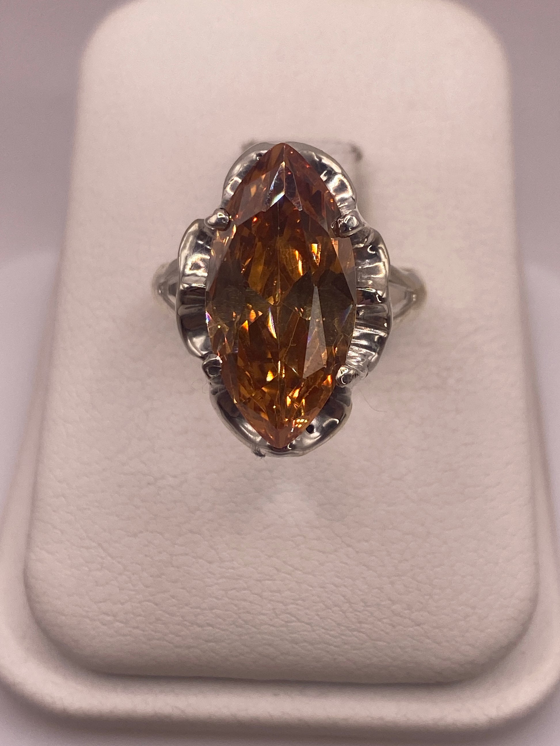 Anillo de plata solitario con circonia café facetada en vitrina blanca