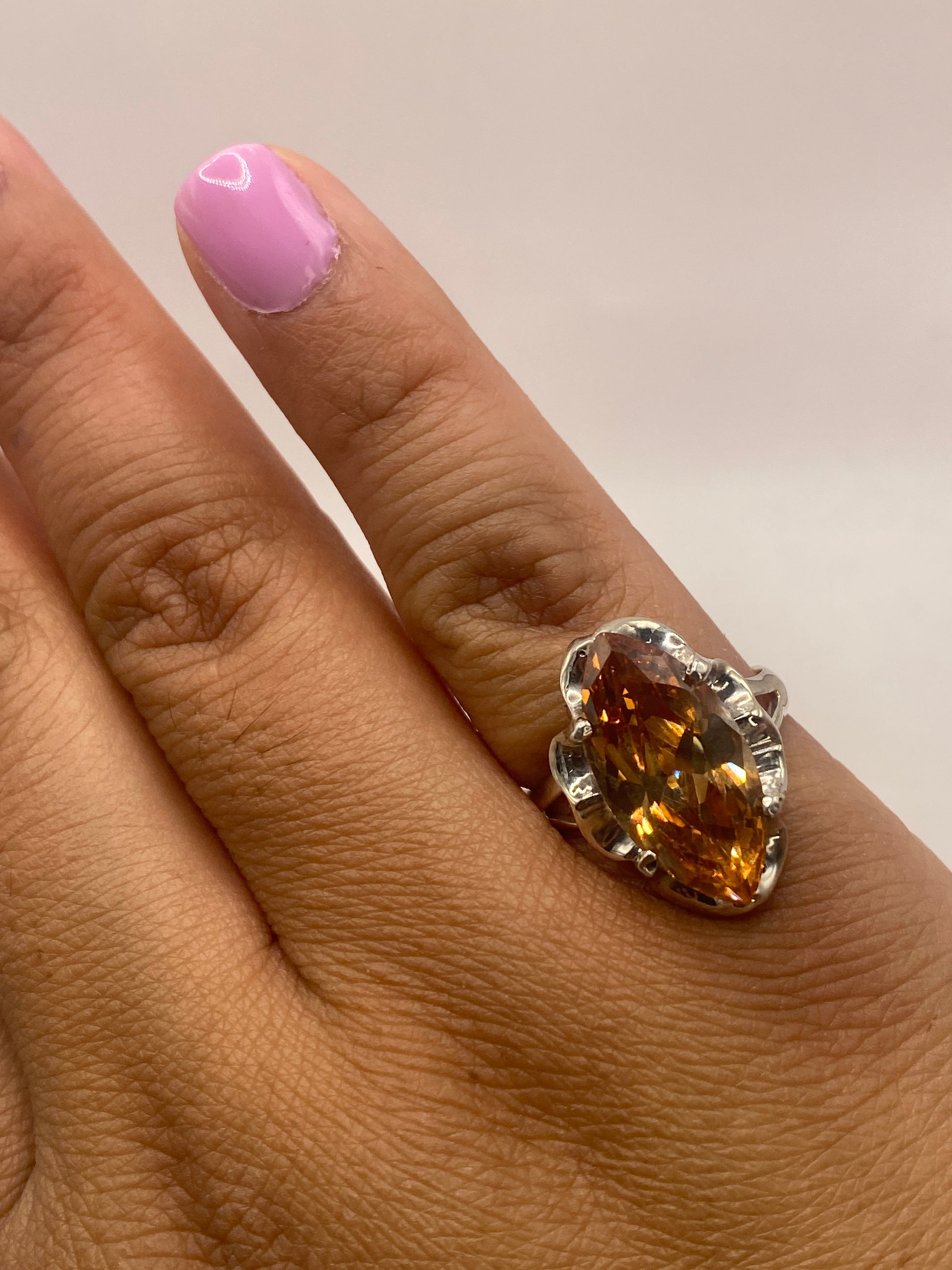 Anillo de plata en la mano mostrando la circonia café y el sello MEXICO925