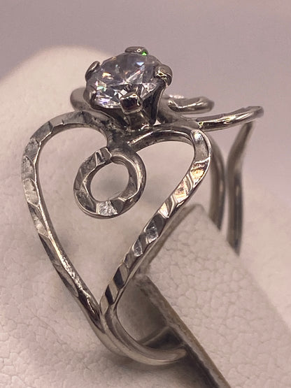 Anillo en forma de corazón de plata con circonia, llevado en la mano