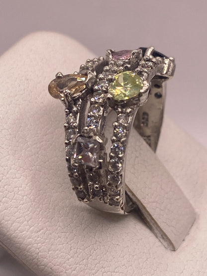 Anillo de coctel multicolor puesto en dedo, mostrando brillo y fuego de las piedras