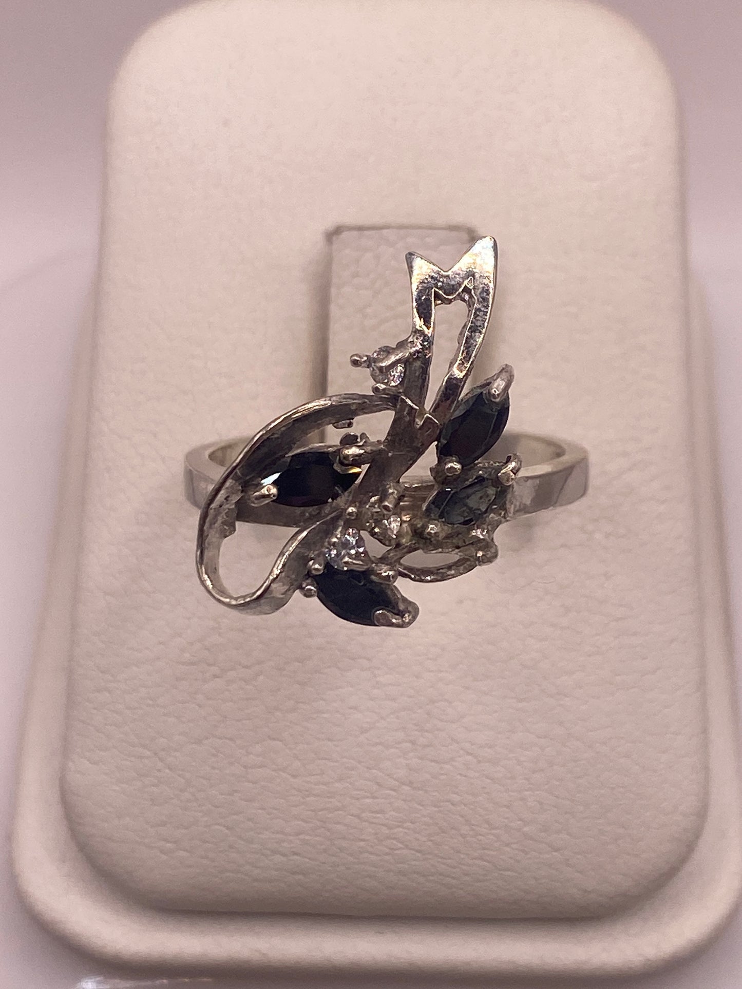 Anillo de plata solitario con circonia negra brillante en dedo de mujer con esmalte rosa